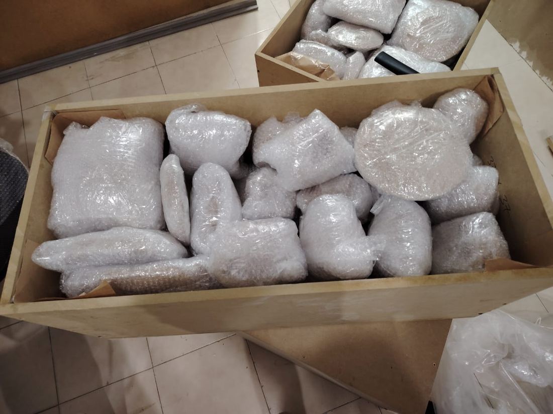 Caja de cartón llena de piezas envueltas y relleno de protección